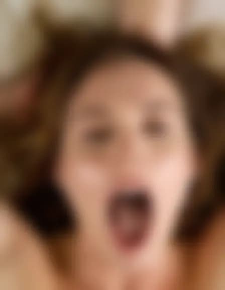 Zoe enjoying a facial cumshot in a messy bedroom.