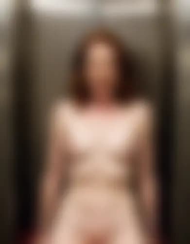 Evelyn, in a confined elevator, reaches orgasm under emergency lights.