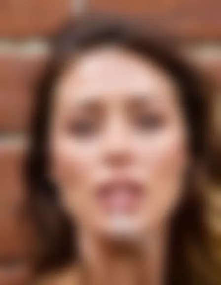 Olivia in a cumshot facial in a shadowy alley behind a coffee shop.