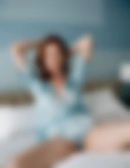 Evelyn in a minimalist bedroom, soft lighting.