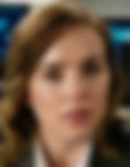 Zoe takes a facial cumshot in a dimly lit office.